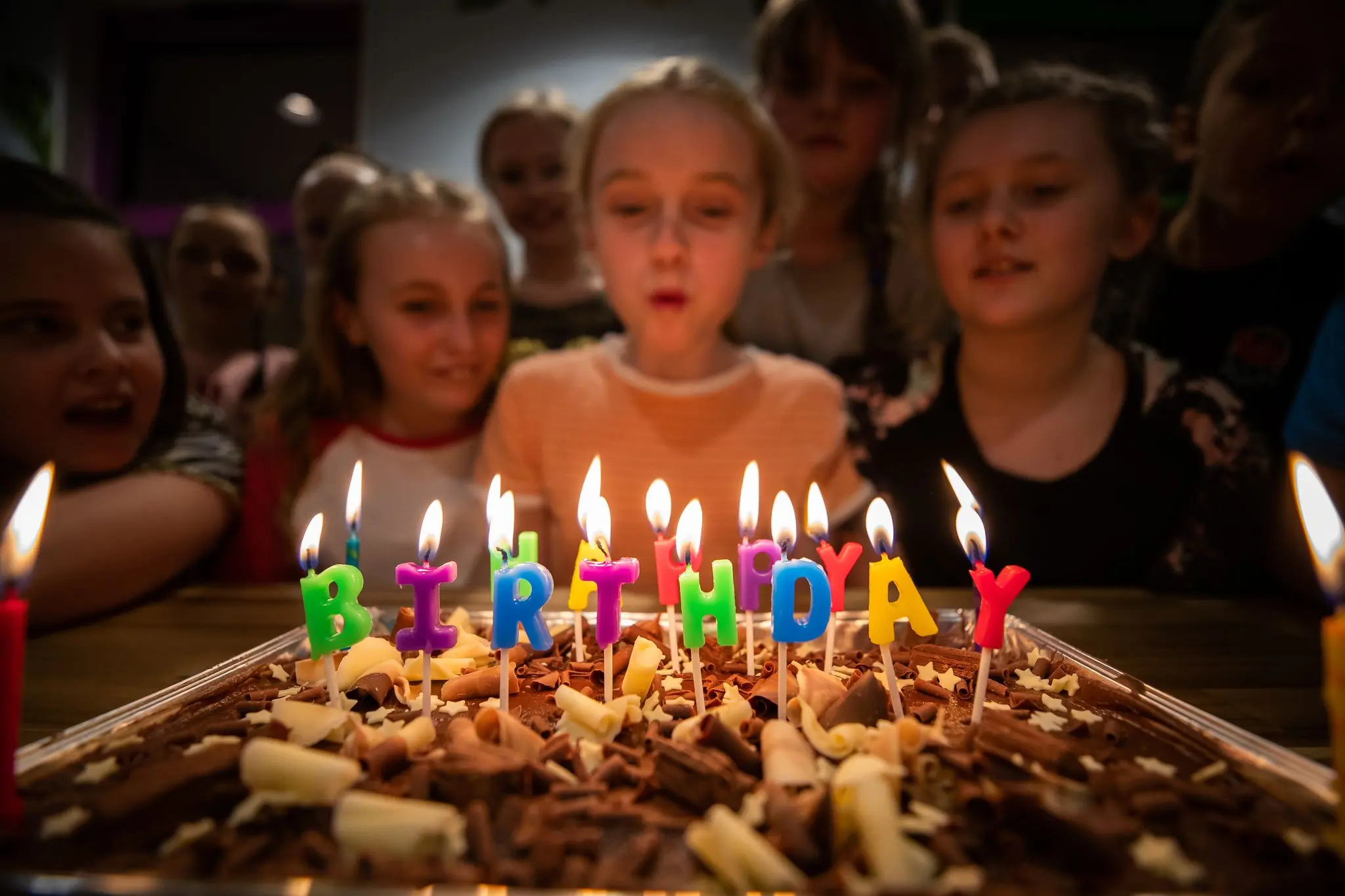 Children blowing out candles on birthday cake
