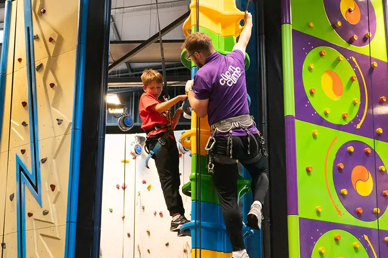 Child and instructor on indoor climbing wall